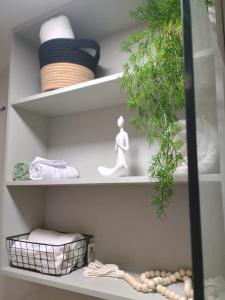 ein Regal mit Handtüchern und eine Statue einer Frau in der Unterkunft Flat Porto de Galinhas in Porto De Galinhas