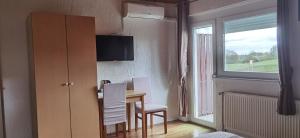 a room with a table and chairs and a window at House Viktoria in Seliste Dreznicko