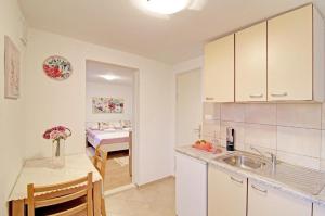 杜布罗夫尼克Apartman Luka的一个带水槽和桌子的厨房