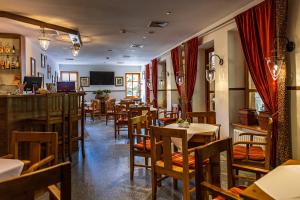 a restaurant with tables and chairs and a bar at Hotel Fero Lux in Korbielów