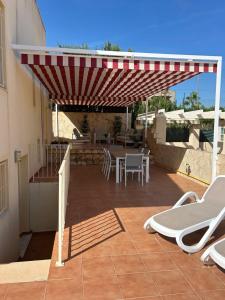 a patio with a table and chairs under a roof at Casa Lucero in Rojales