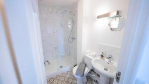 ein weißes Badezimmer mit Dusche und Waschbecken in der Unterkunft The Townhouse - FREE Parking & Wi-FI in Stratford-upon-Avon