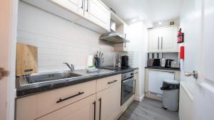 eine kleine Küche mit einer Spüle und einer Theke in der Unterkunft The Townhouse - FREE Parking & Wi-FI in Stratford-upon-Avon