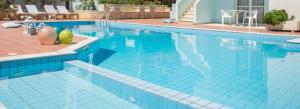 una grande piscina con piastrelle blu in un edificio di Camelot Royal Beds by Estia a Mália