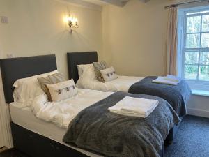 two beds in a room with towels on them at Temple Croft Bed and Breakfast in Alston