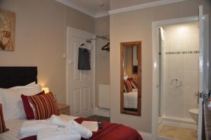 a bedroom with a bed and a bathroom with a shower at Hotel Peppers in Torquay +77 photos