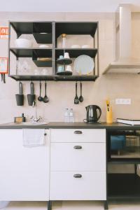 a kitchen with white cabinets and black shelves at PTM DownTown in Portimão +44 photos