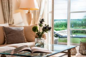 sala de estar con sofá y mesa de cristal con libro en Precise Resort Schwielowsee - Hotel, en Werder 53 fotos más