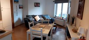 a living room with a couch and a table at Centraal appartement met tuintje, vlak bij zee in De Panne