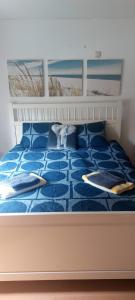 un letto con due cuscini sopra di Centraal appartement met tuintje, vlak bij zee a De Panne