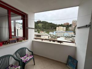 a balcony with two chairs and a window with a view at Volga Cozy Apartment in Durrës