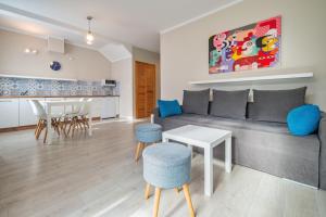 a living room with a couch and a table at Apartamenty Wczasowa - z widokiem na góry, parkingiem, rowerownią in Kudowa-Zdrój