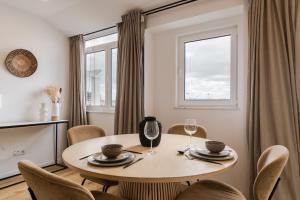 a dining room with a table and chairs and a window at Casa Boma Lisboa - Sea View Apartment With Private Sunny Terrace - Alges I in Algés