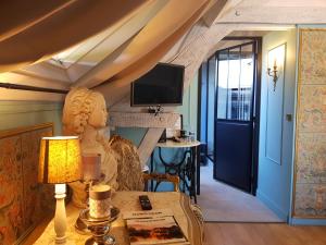 a living room with a table and a tv at La Perle Secrète in Theneuille