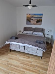 a bedroom with a large bed and a wooden floor at Haus Emilia in Sierosław