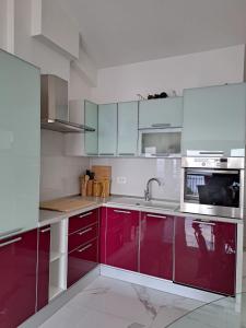 a kitchen with red cabinets and a microwave at Apartman SIX in Brela