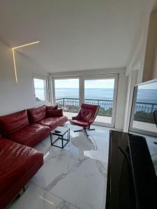 a living room with a red couch and a chair at Apartman SIX in Brela