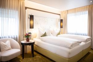 Un dormitorio con una gran cama blanca y una silla. en weila, en Arnsberg