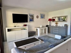 a living room with a couch and a flat screen tv at Appartement 3 pièces- 4 personnes- ARGELES VILLAGE AR075-012 in Argelès-sur-Mer +8 photos