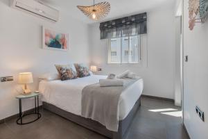 a white bedroom with a bed and a window at Victoria luxury in Málaga