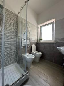a bathroom with a shower and a toilet and a sink at Simo'sunset House in Focene
