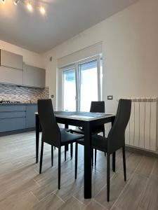 a dining room with a black table and chairs at Simo'sunset House in Focene +26 photos