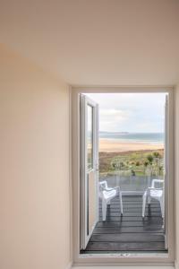 an open door to a balcony with a view of the ocean at The Penellen guest accommodation room only in Hayle