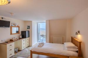 a bedroom with a bed and a television and a window at The Penellen guest accommodation room only in Hayle