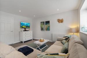 una sala de estar con un sofá y una mesa en The Snug - Brixham, en Brixham 17 fotos más