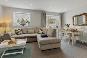 una sala de estar con un sofá y una mesa en The Snug - Brixham, en Brixham