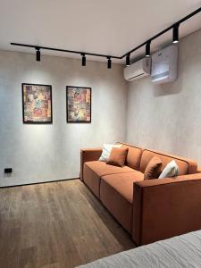 a living room with a brown couch in a room at Квартира 4-36 in Balqash
