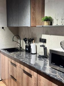 a kitchen counter with a sink and a microwave at Квартира 4-36 in Balqash