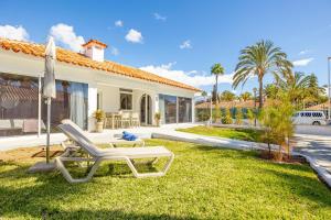 a house with a lawn chair and an umbrella at LUXURY Sun Club 252 in San Bartolomé de Tirajana