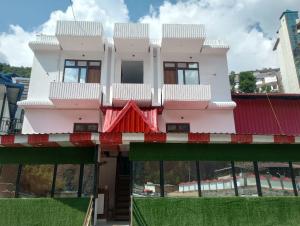 RudraprayāgHotel Mahadev的一座粉红色的建筑,上面设有一个阳台