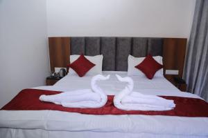 RudraprayāgHotel Mahadev的两只白天鹅躺在床上