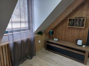 a room with a wooden wall with a bench and a window at Penzión Kupfer in Staré Hory