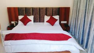 RudraprayāgHotel Mahadev的卧室里有一张大床，配有红色枕头