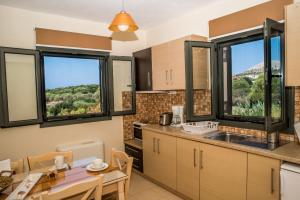 a kitchen with a table and a dining room at Korallis Villas in Karavadhos