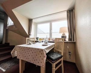 a dining room table with two chairs and a window at Solbeck im Käpitänshaus Andresen in Westerland (Sylt) +11 photos