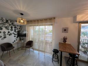 a living room with a table and chairs and a window at Studio Cannes Californie in Cannes