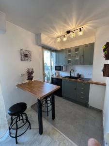 a kitchen with green cabinets and a wooden table at Studio Cannes Californie in Cannes