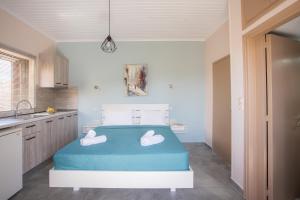 a bedroom with a bed with two towels on it at Eros appartments in Kalamitsi +35 photos