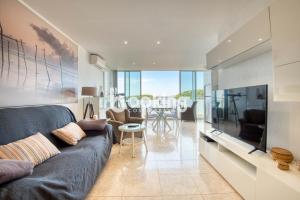 a living room with a blue couch and a table at Kaminias Apartament amb vistes al mar reformat per 4 persones in Platja  d'Aro