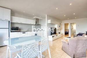 a kitchen and living room with a table and chairs at Kaminias Apartament amb vistes al mar reformat per 4 persones in Platja  d'Aro