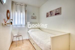 a white bedroom with a bed and a chair at Kaminias Apartament amb vistes al mar reformat per 4 persones in Platja  d'Aro