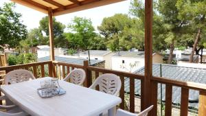 a white table and chairs on a wooden deck at Camping Tikayan Le Méditerranée - Maeva in Hyères