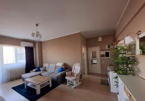 a living room with a couch and a table at Homey Apartment Vacaresti in Bucharest