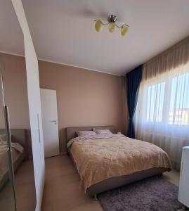 a bedroom with a bed and a window at Homey Apartment Vacaresti in Bucharest