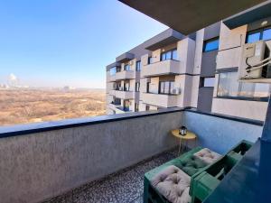 a balcony of a building with a couch and a table at Homey Apartment Vacaresti in Bucharest