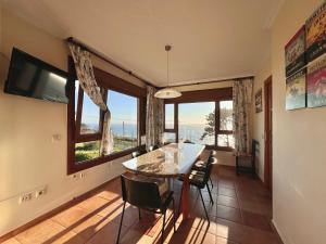 a dining room with a table and chairs and windows at ROOMS PEREGRINOS A Casa Alicia in Rosal